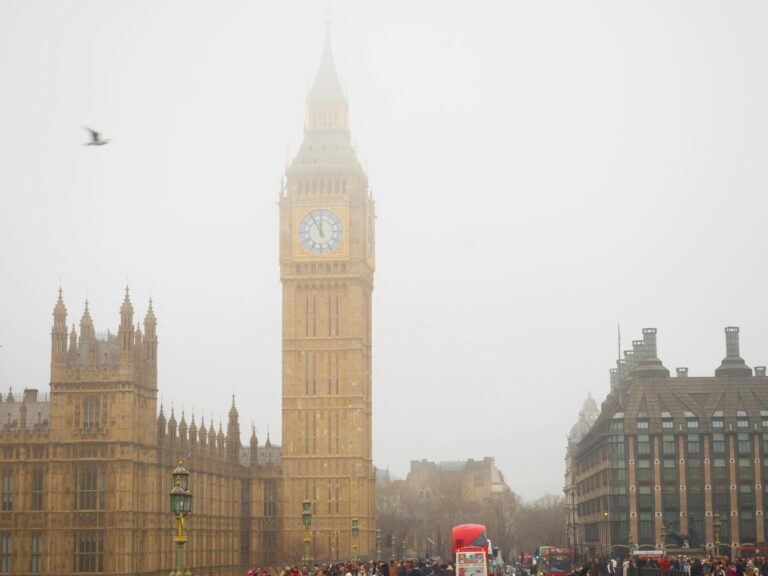 Iconic Big Ben tower enveloped in fog with bustling London street scene.
