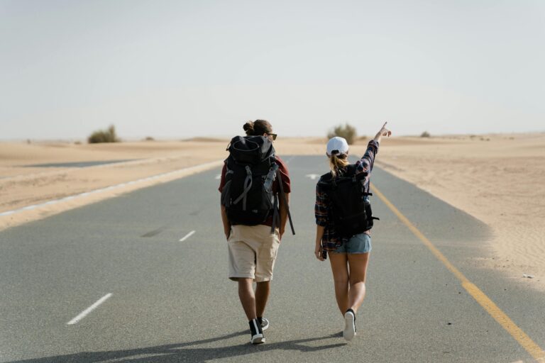 Adventure in the desert with two people walking down a long road.